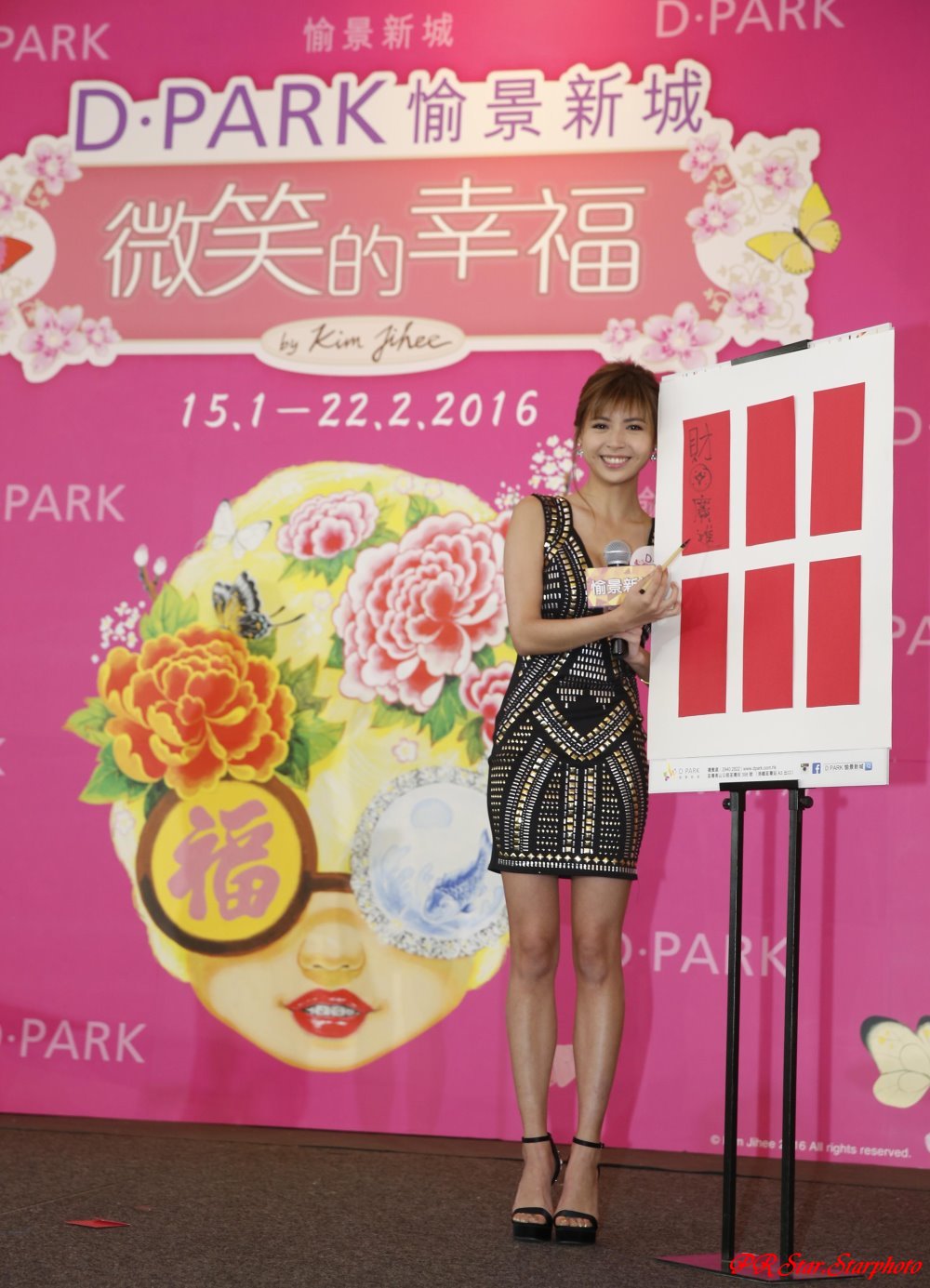 張秀文在「一家笑口寫揮春」自創賀詞的遊戲環節，用毛筆寫上「財源廣進」。.JPG